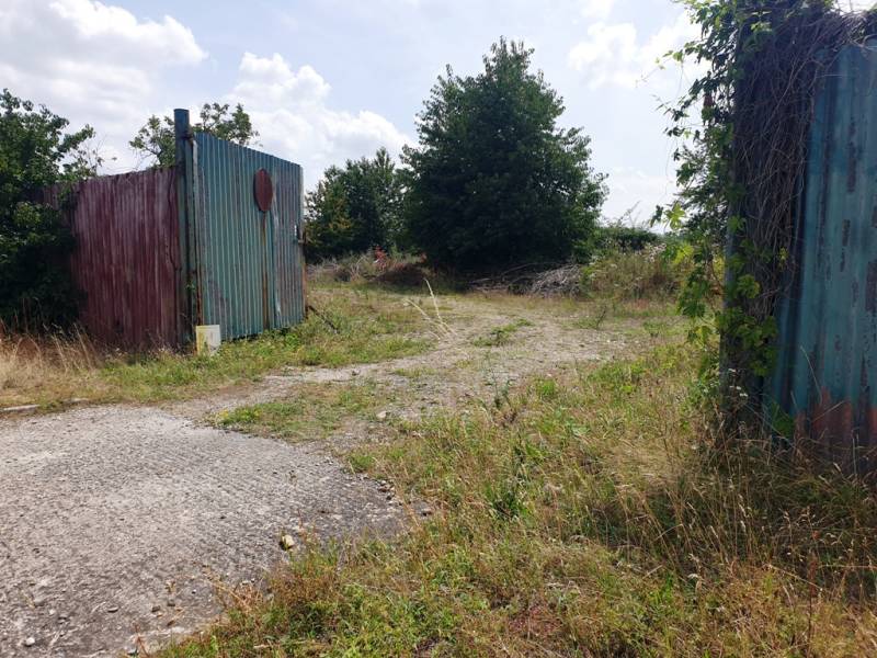 Entrance gate and overgrown land in Trenčianske Bohuslavice, suitable for commercial plots.