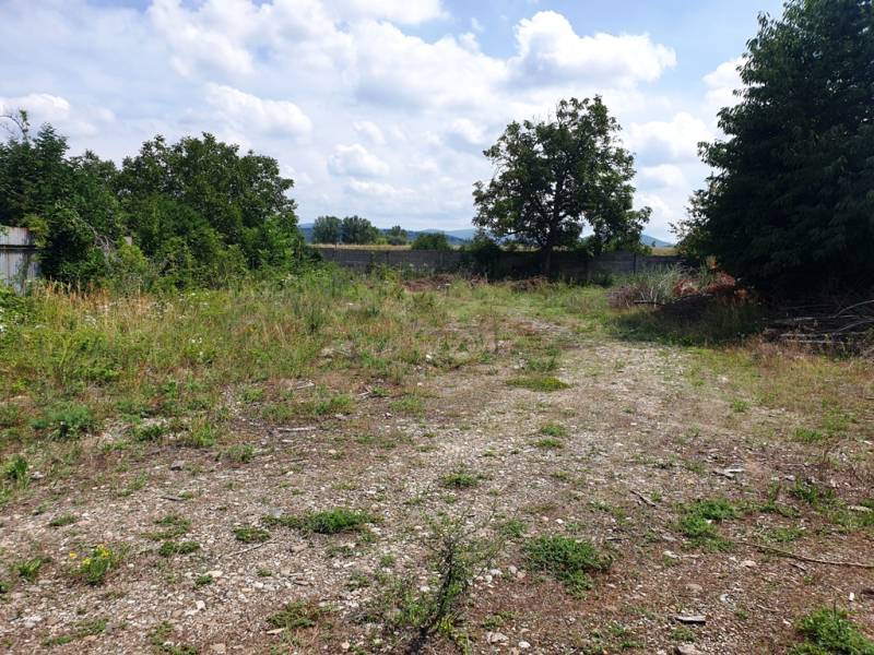Land in Trenčianske Bohuslavice with bushes and trees in the background. Commercial land.