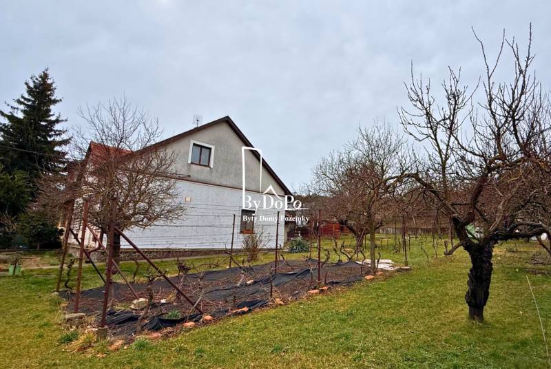 A family house on Železničiarska Street in Nitra surrounded by a garden and trees.