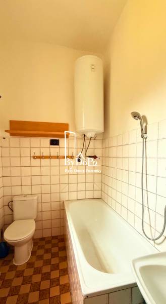 Bathroom in a family house with a bathtub, boiler, and toilet.