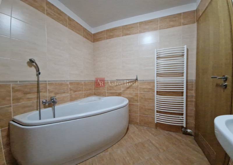 Bathroom with a bathtub and a ladder radiator in a holiday apartment.