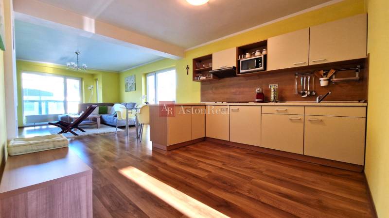 Bright kitchen with a sofa in the Holiday Apartment, open space with wooden flooring.
