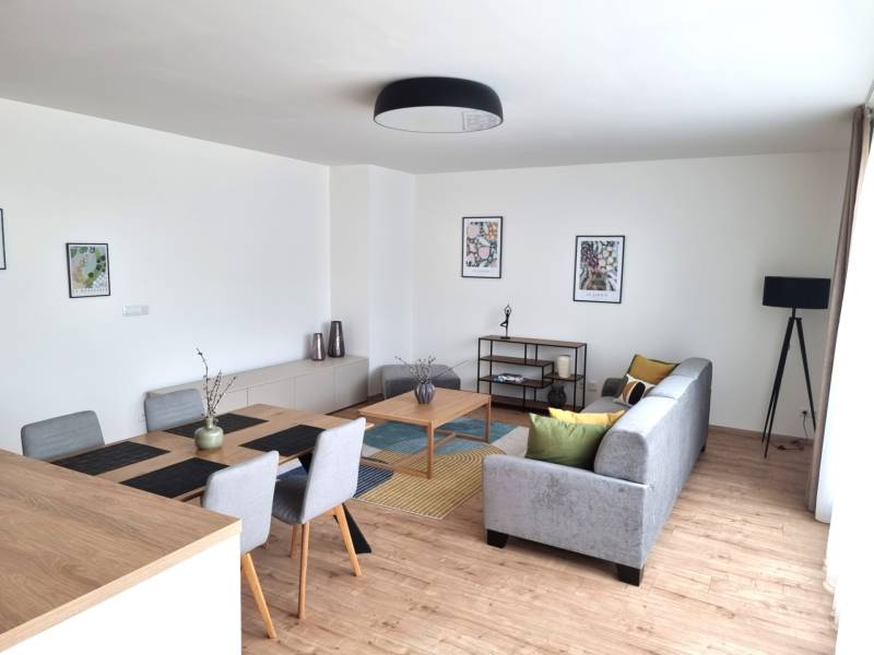 Living room in a 3-room apartment with a dining table, sofa, and decorations.