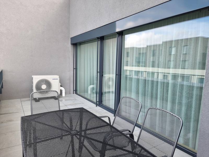 A balcony in a 3-room apartment with metal furniture and air conditioning.