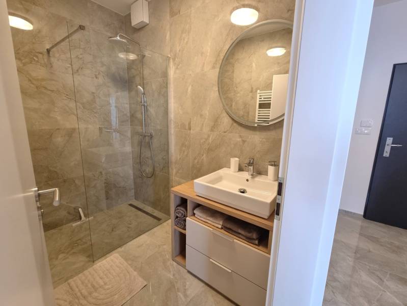 A bathroom in a 3-room apartment with a shower corner and a washbasin cabinet.