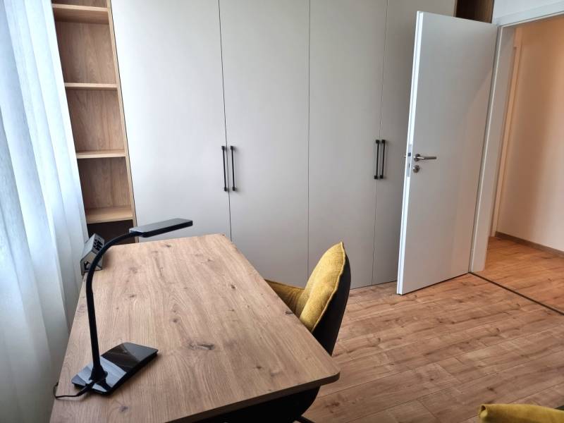 A workspace with a wooden desk and chair in a 3-room apartment.