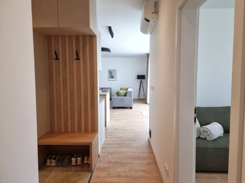 A hallway with a wardrobe and a view into the living room in a 3-room apartment.