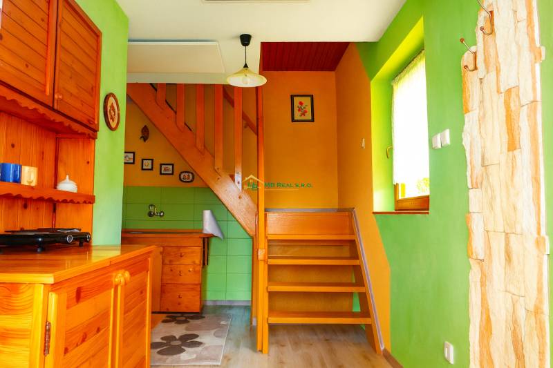 A colorful cabin interior with a staircase and wooden furniture.