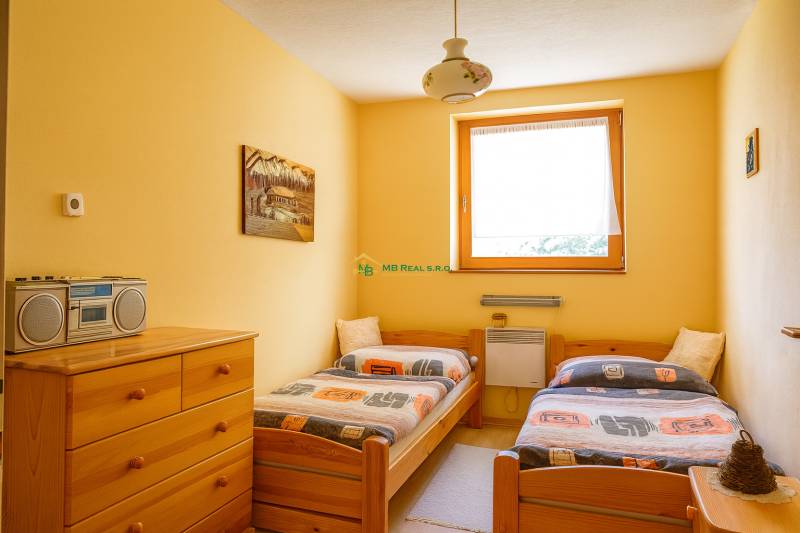Double room in a cabin with wooden furniture and a radio on the dresser.