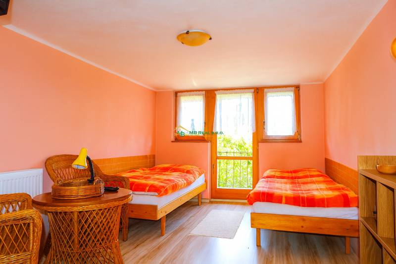 A double room in a cottage with wicker furniture and pastel-colored walls.