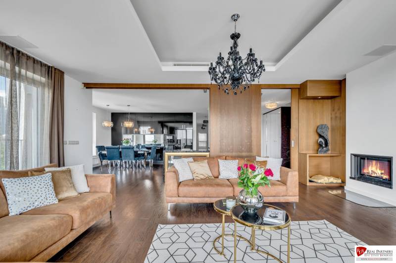 Elegant living room with a sofa, fireplace, and light fixture in a 4-room apartment.