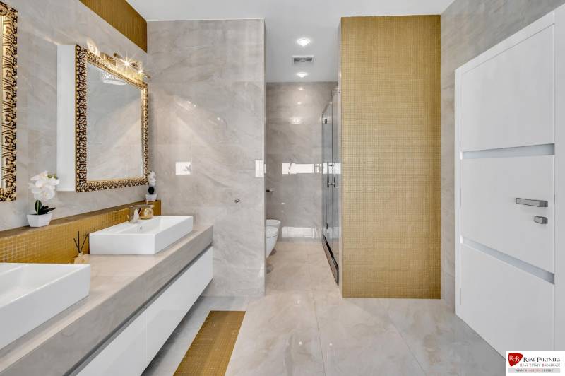 A luxurious bathroom with a double sink and gold details in a 4-room apartment.