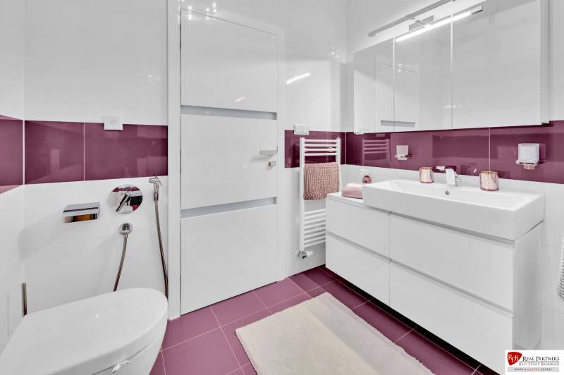 A bathroom in a 4-room apartment with purple tiles and modern equipment.