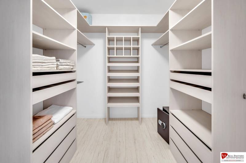 A wardrobe with light shelves and storage space in a 4-room apartment.