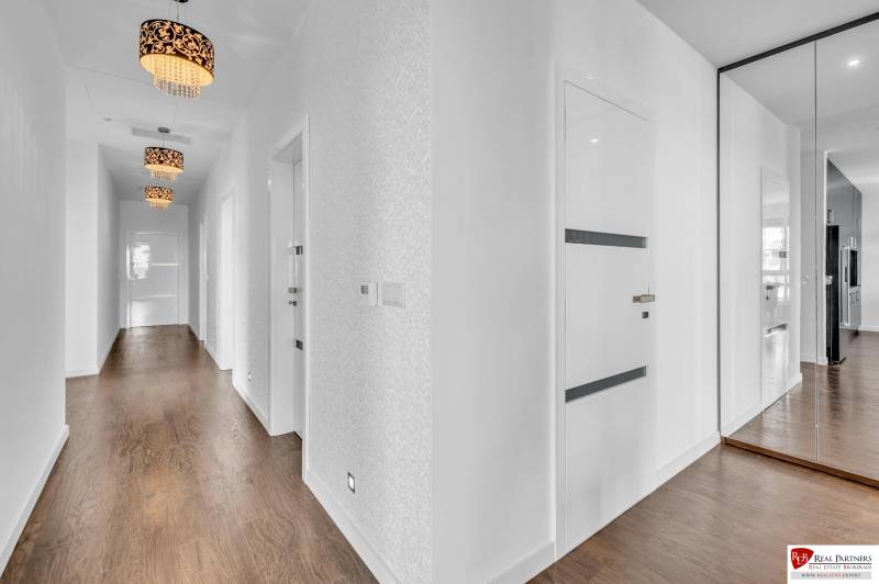 Hallway of a 4-room apartment with a mirrored wardrobe and wooden floor.