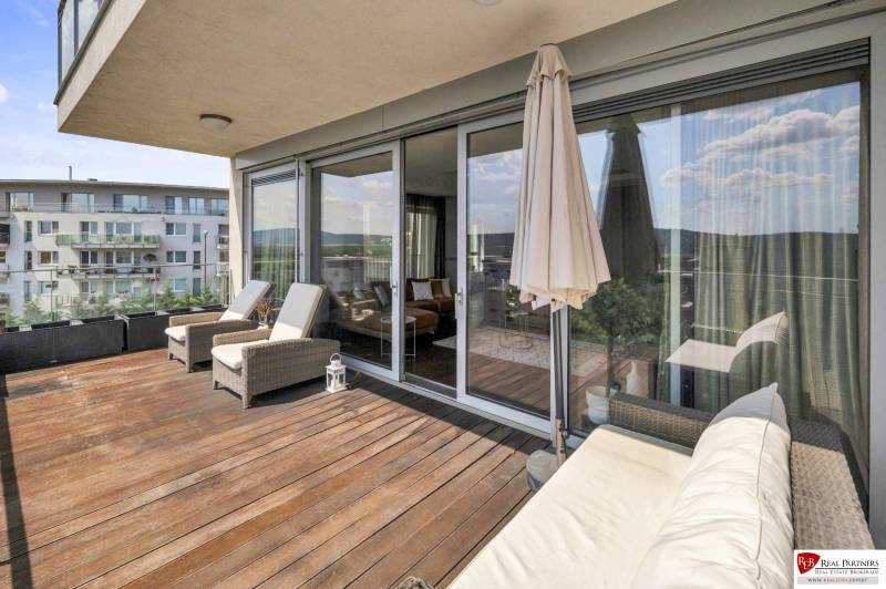 Terrace of a 4-room apartment in Bratislava - Karlova Ves with comfortable loungers and a sofa.