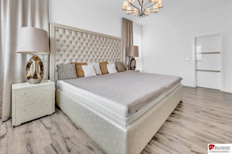 Luxury bedroom with a large bed and a stylish chandelier in a 4-room apartment.