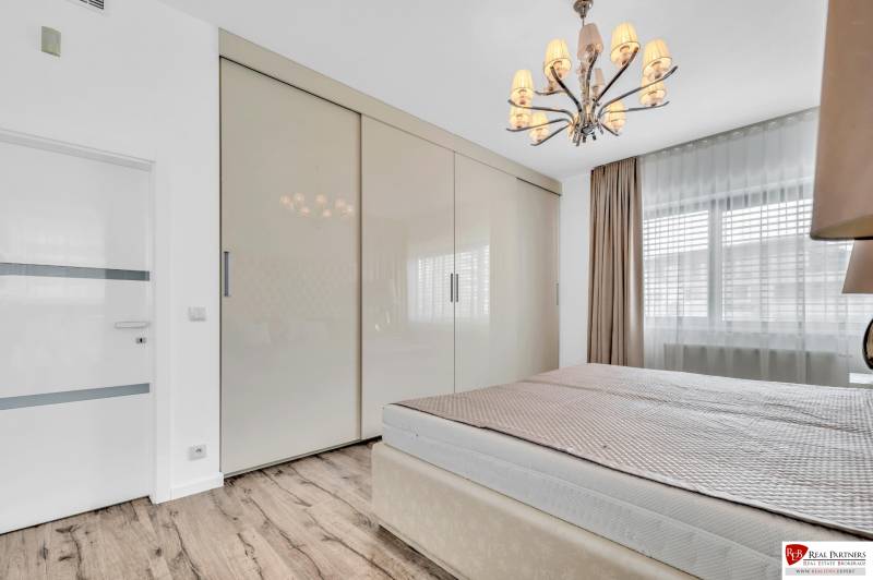 Bedroom with a wardrobe and a chandelier in a 4-room apartment.