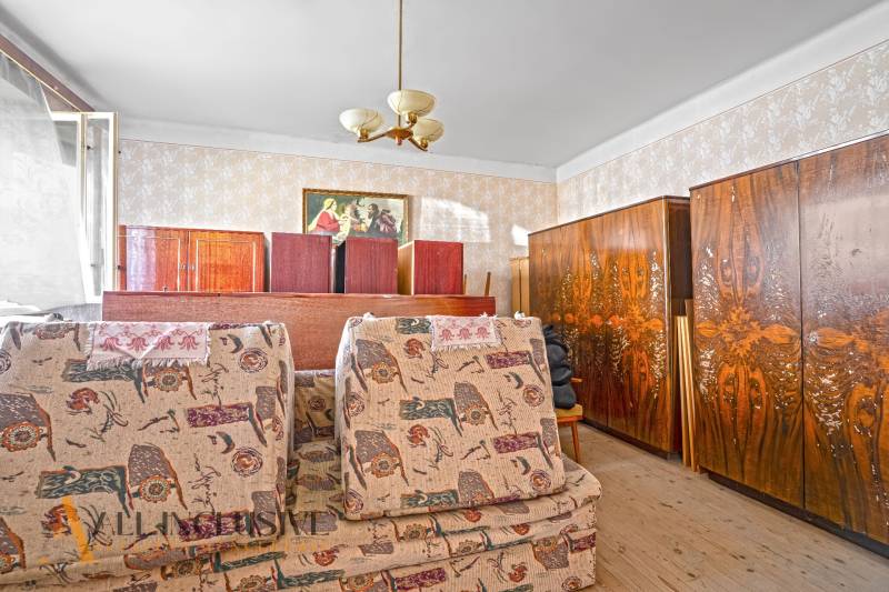 A room in a family house with antique furniture and decorative wallpaper.