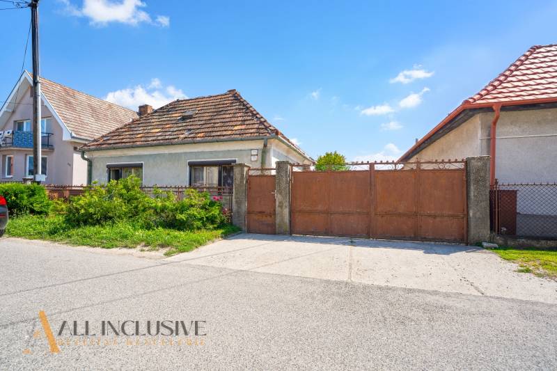 A family house in Jahodná with a brown gate and a garden in front of the entrance.