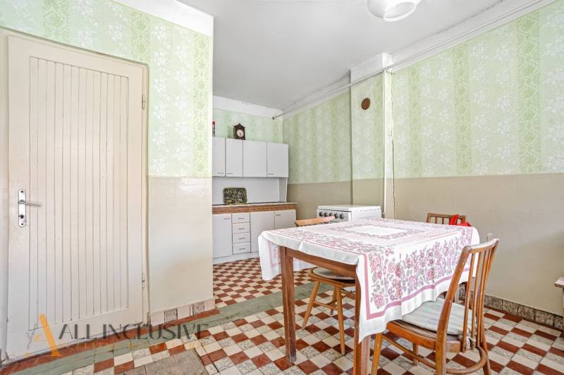 A kitchen in a family house with a dining table, chairs, and a kitchen unit.