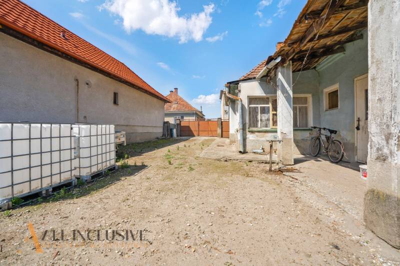 The courtyard of a family house in Jahodná with a bicycle and large water tanks.