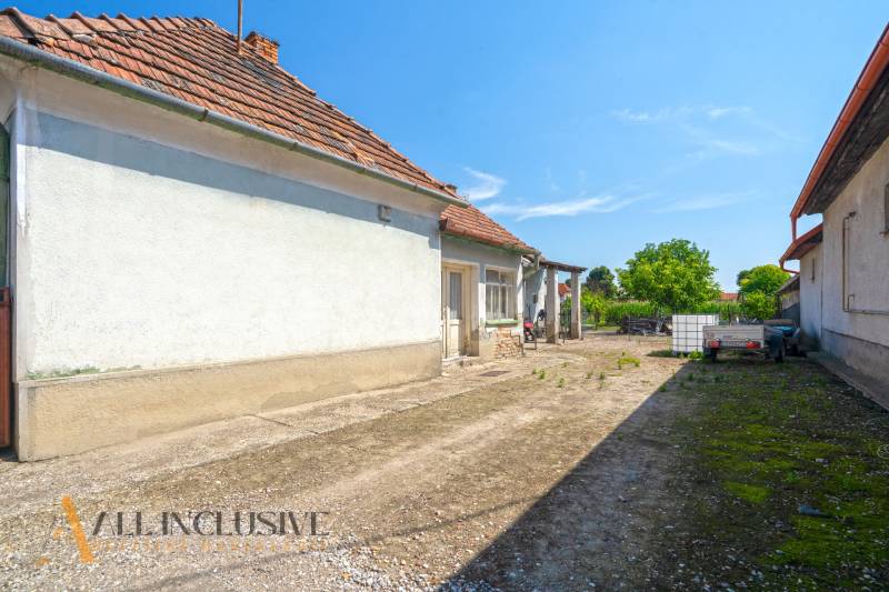 Courtyards of a family house in Jahodná with a trailer, a tank, and greenery.