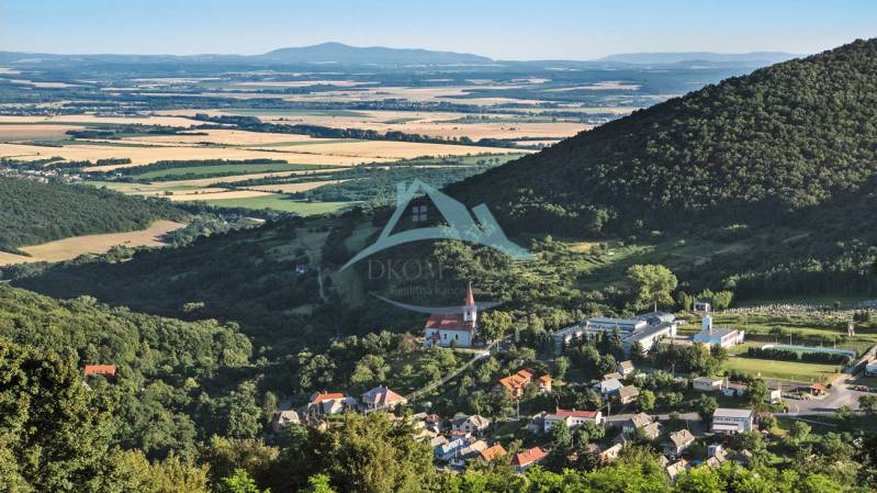 Panoramic view of a village in a valley, surrounded by forests and fields. Land suitable for living.