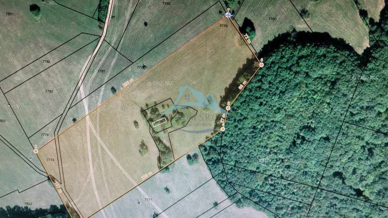 Aerial view of a plot surrounded by forest, ideal for living and investment.