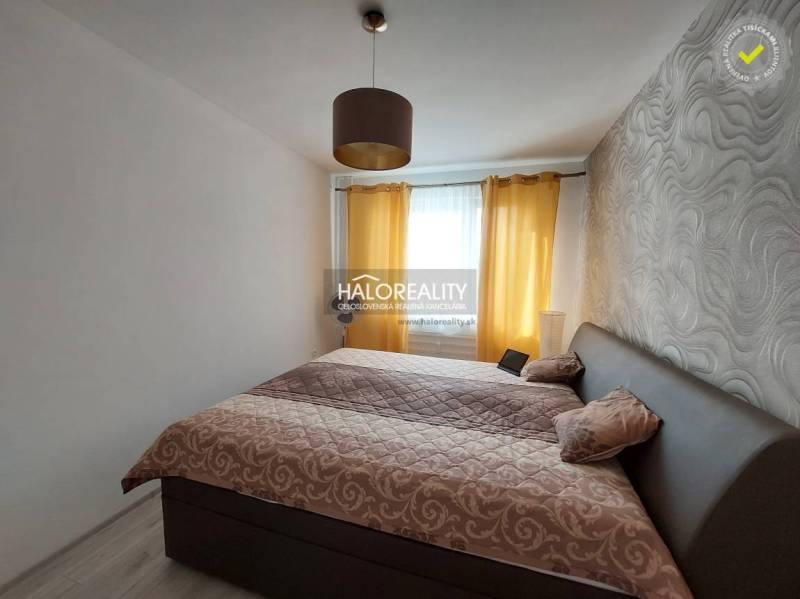 A bedroom with patterned wallpaper and curtains in a 3-room apartment.