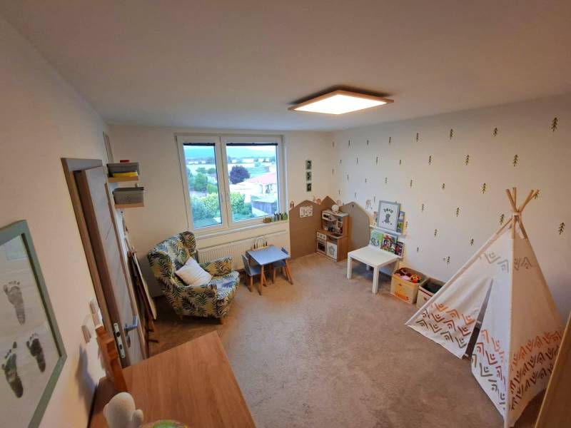 Children's room of a 4-room apartment with a chair, table, and tent.
