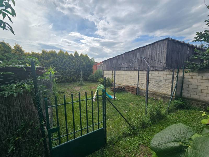 A garden at a 4-room apartment in Kočovce with a green lawn and a fence.
