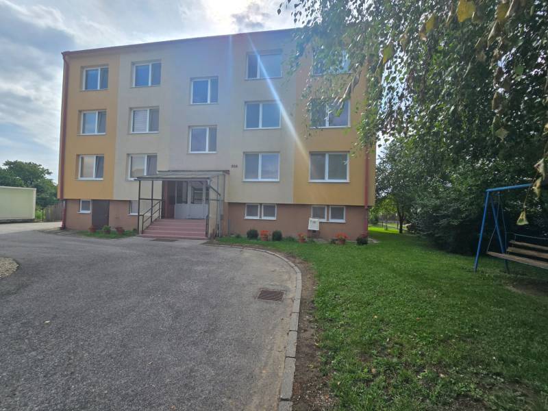 Exterior of a 4-room apartment in Kočovce, a three-story apartment building with greenery.