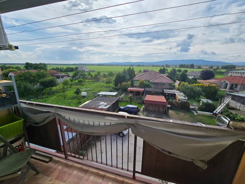 The view from the apartment in Kočovce of gardens, houses, and hills in the distance.