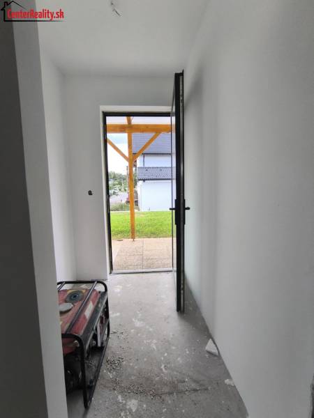 A hallway in a family house with open doors, view out to the garden.
