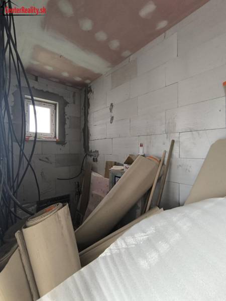 Building materials and electrical installation in a partially completed room of a family house.