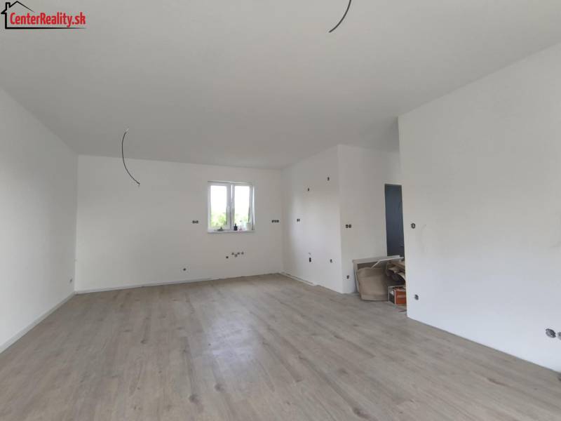 Interior of a family house with wooden flooring, white walls, and preparation for electrical installation.