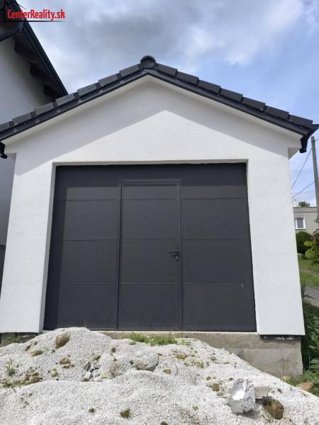 A family house in Malé Krštenany with a white garage and dark doors.