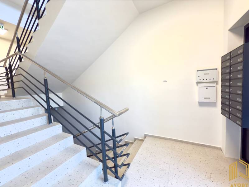 Entrance hall in a studio apartment with mailboxes and a staircase.
