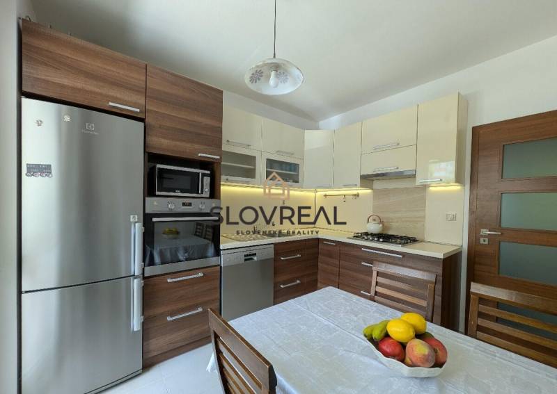 A kitchen in a 4-room apartment with wooden cabinets and stainless steel appliances.