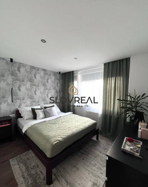 Bedroom in a 4-room apartment with a comfortable bed, a plant, and furniture.