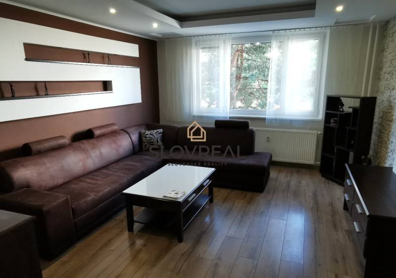 A comfortable living room with a brown sofa and wooden flooring in a 4-room apartment.