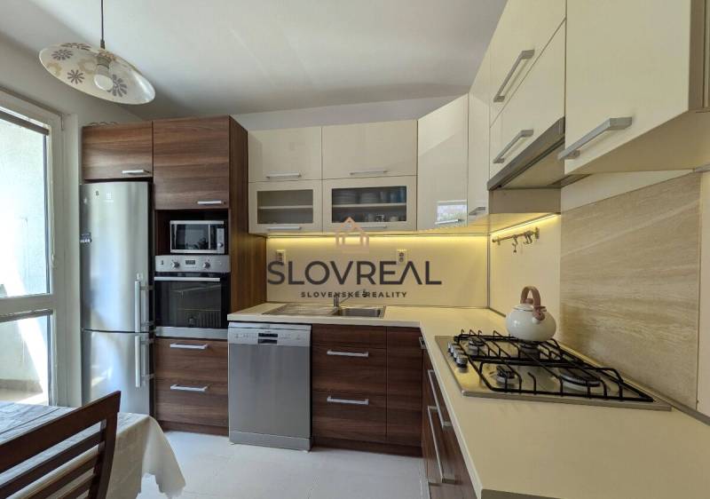 A kitchen in a 4-room apartment with wooden cabinets, a stove, and a refrigerator.