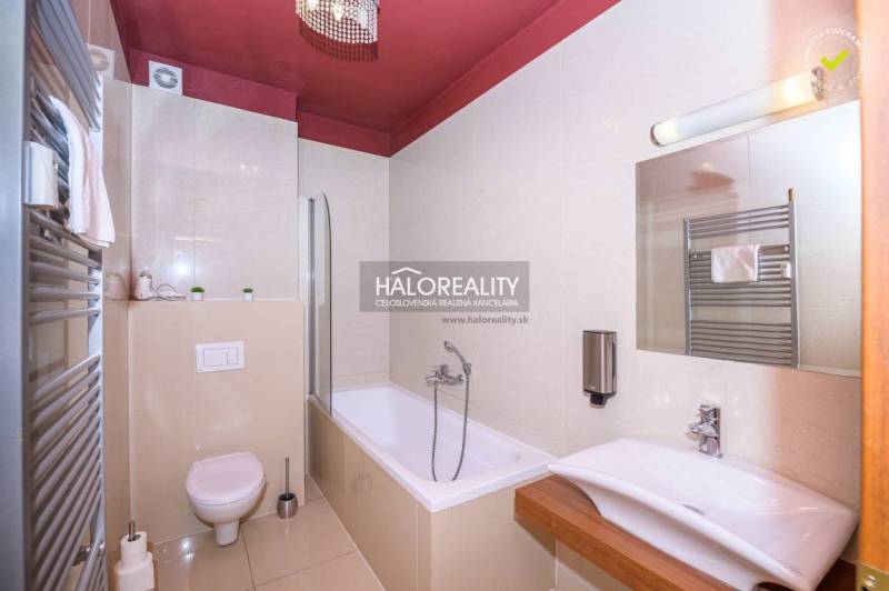 Bathroom in a 2-room apartment with a bathtub, sink, toilet, and towel rack.