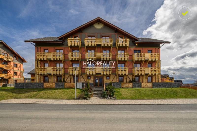 The exterior of a multi-story building with wooden balconies in the village of Veľká Lomnica.