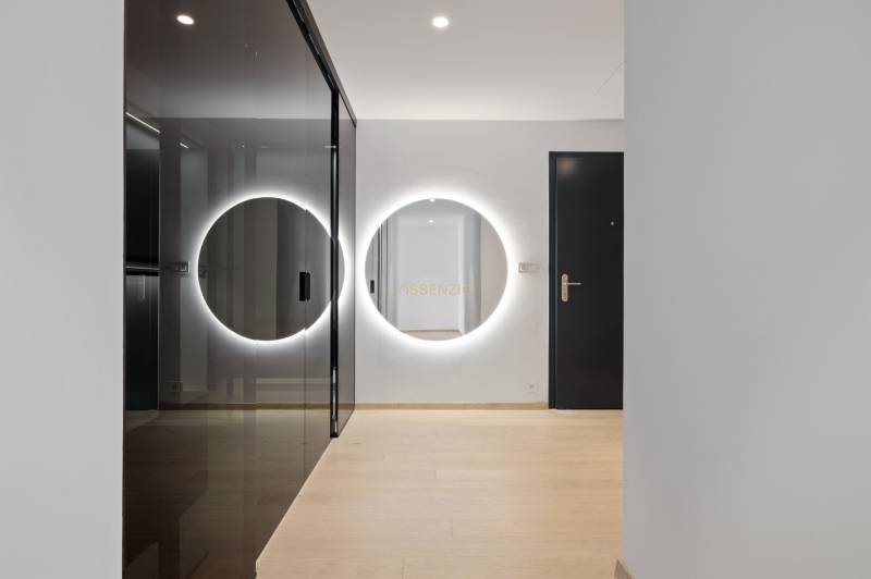 A hallway in a 2-room apartment with a round mirror and a built-in wardrobe.