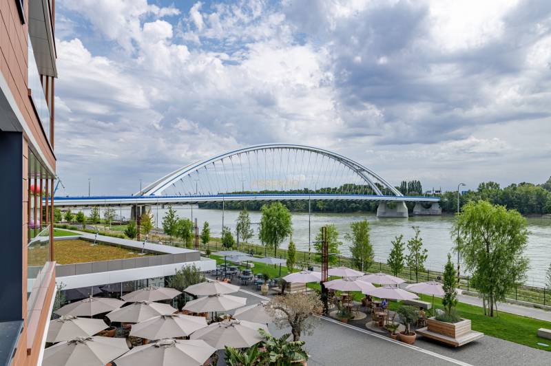Bridge in Bratislava - Old Town, with a view of the river and outdoor seating.