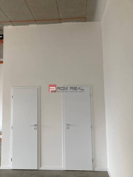 Double white doors in commercial premises with a concrete ceiling.