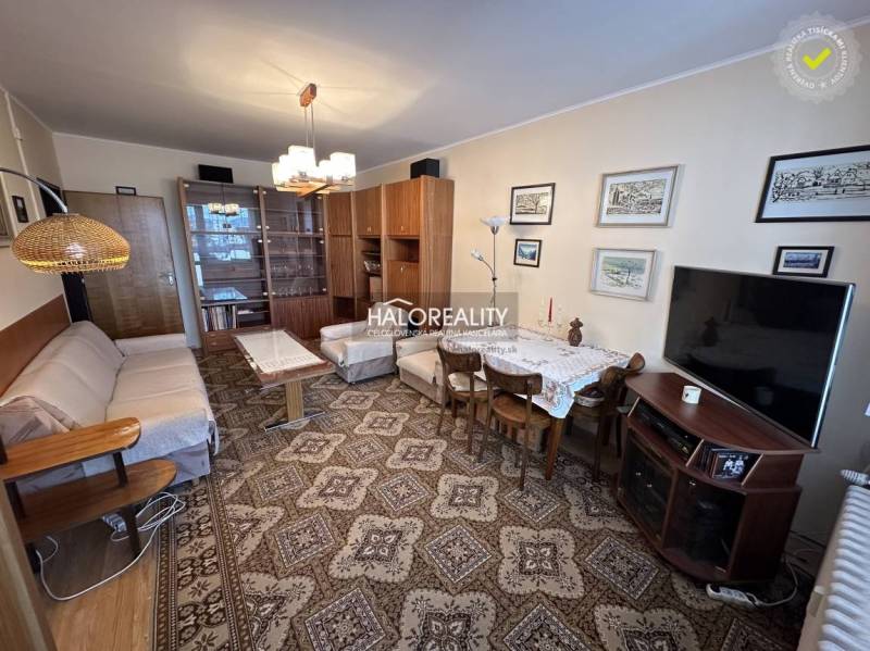 Living room of a three-room apartment with carpets and classic furniture.