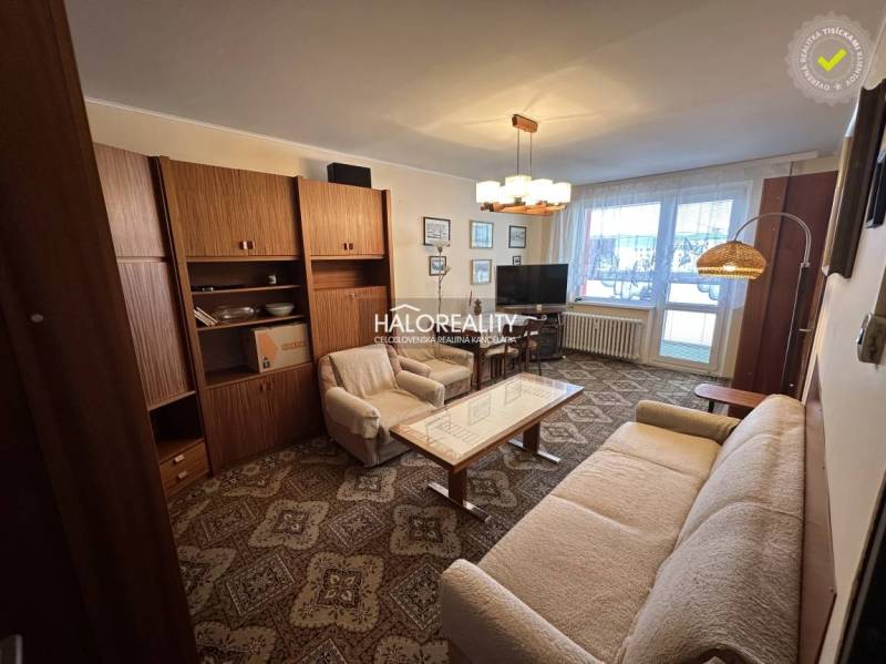 A stylish living room in a 3-room apartment with a sofa, an armchair, and curtains.
